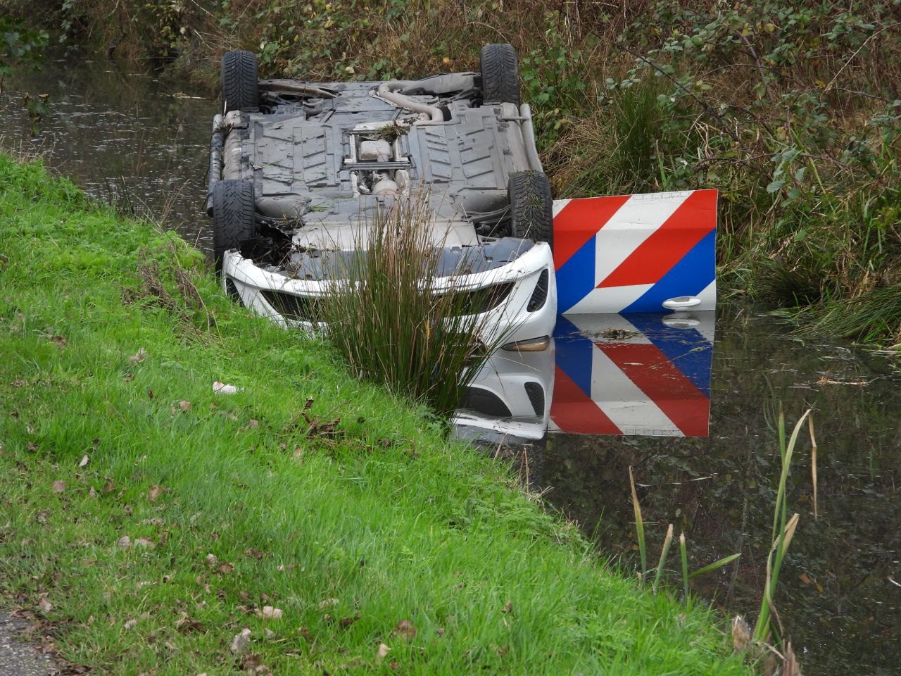 Politieauto op de kop in de sloot na achtervolging in Grou