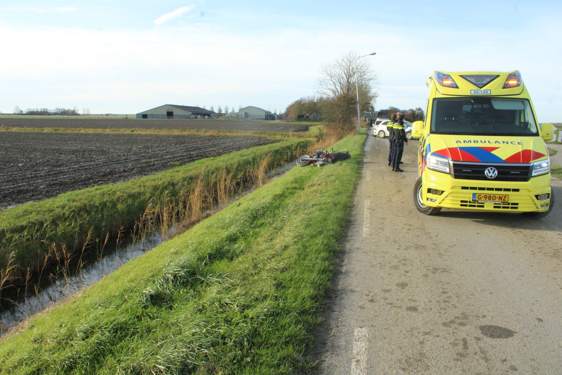 Drek op de weg: bus en motor van de weg in Kimswerd
