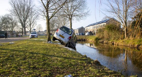 Auto belandt boven sloot in Sneek; Bestuurder gevlucht