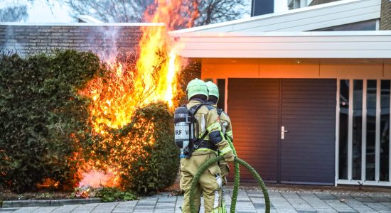 Felle brand in coniferenhaag tegen kerk in Drachten