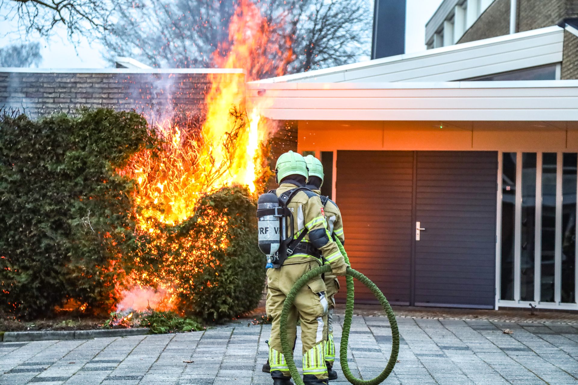 Felle brand in coniferenhaag tegen kerk in Drachten