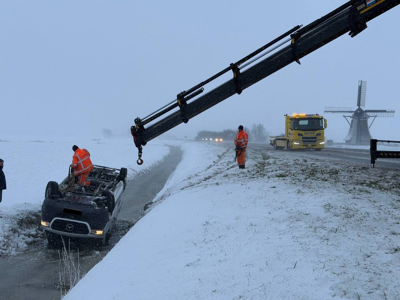 Bestelbus op de kop in de sloot door winterweer bij Wommels