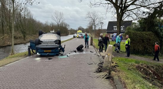 Auto over de kop na botsing met wegversmalling bij Westergeast